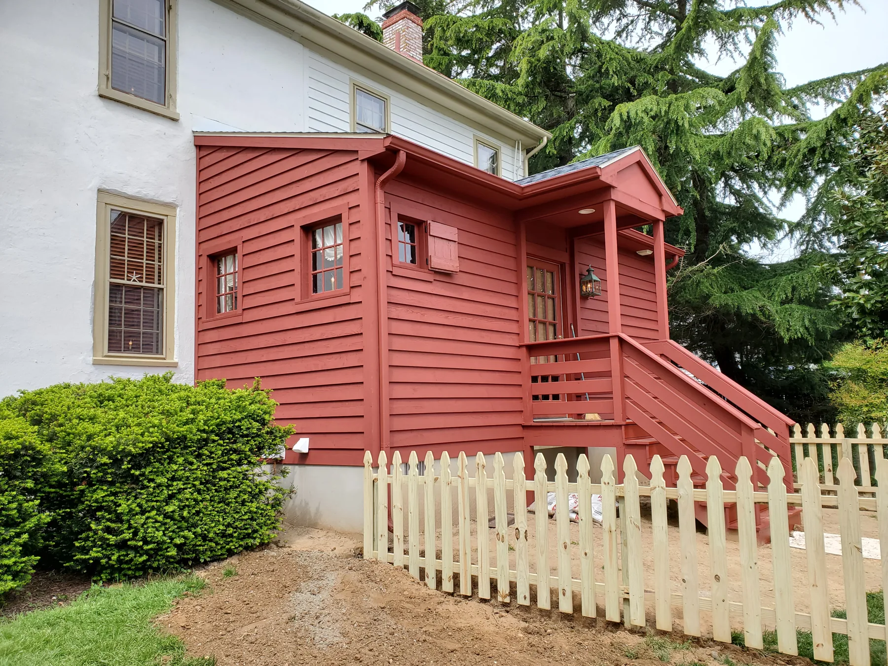 Red exterior addition and stairs beside existing home